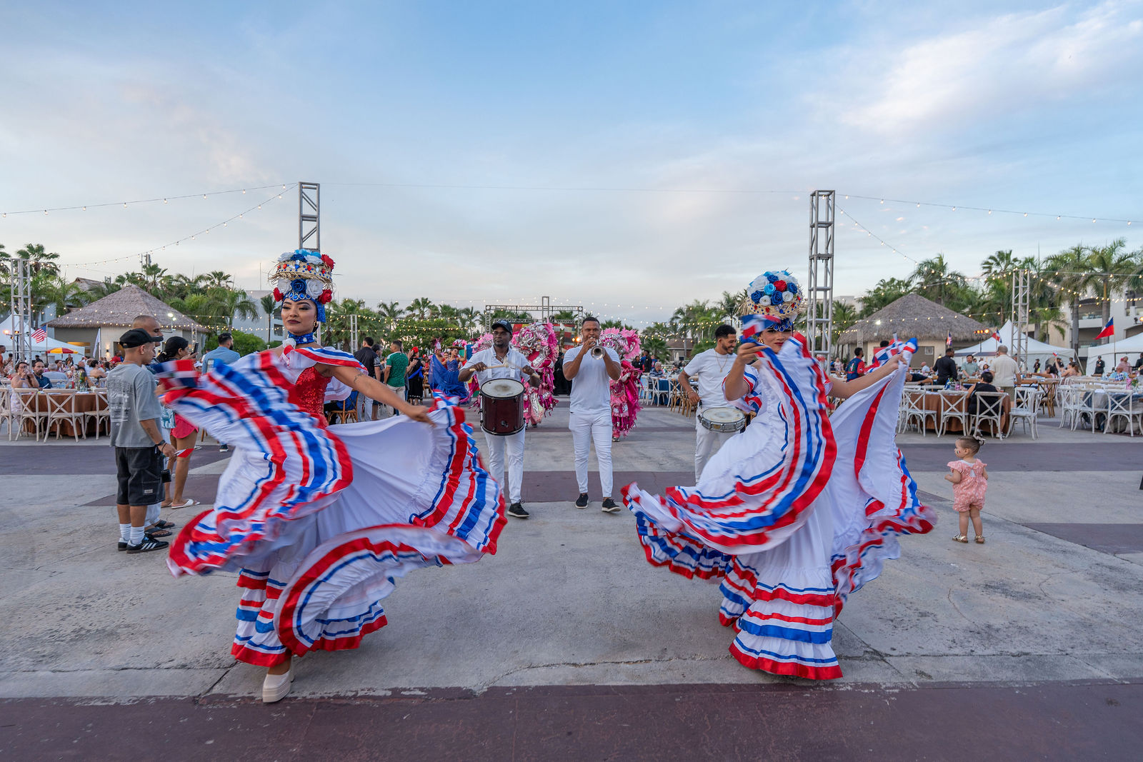 Folkloric dancers in red, white and blue skirts spinning at golden hour