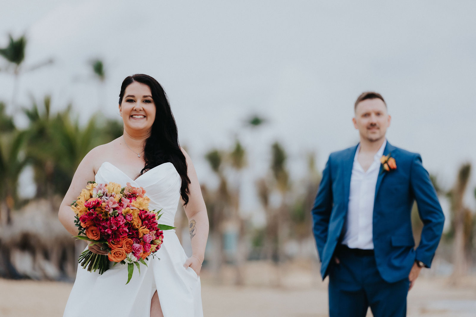 Close portrait of the bride with her orange and pink bouquet