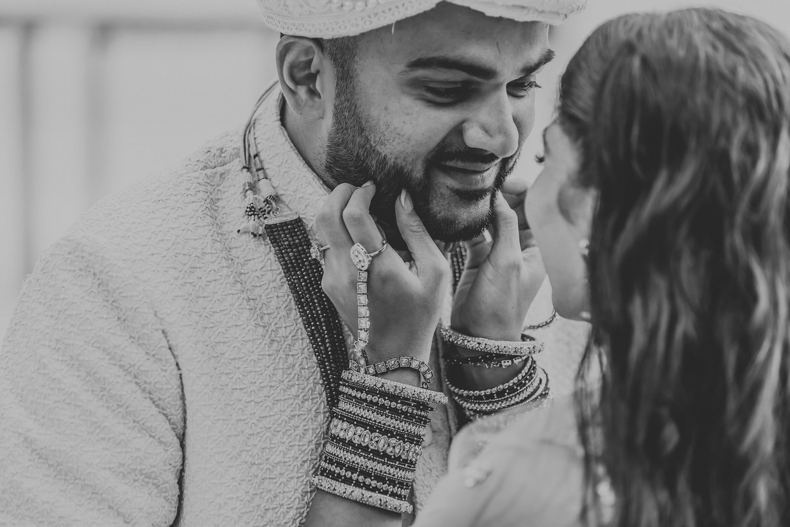 Black and white candid of the groom cradling the bride's face