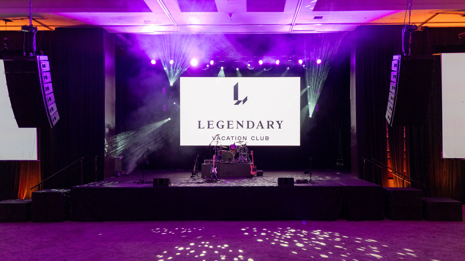 Wide frame of the ballroom under purple stage lighting