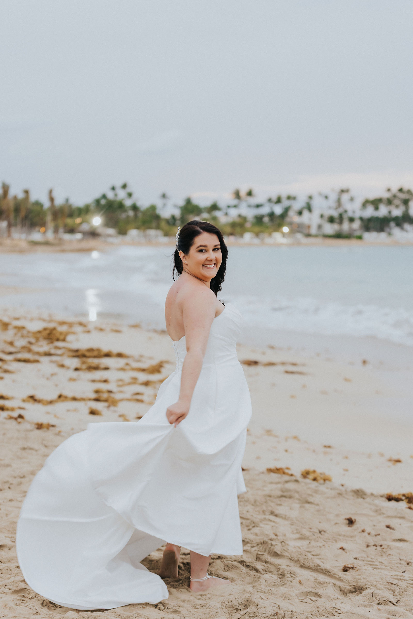 Bride twirling her gown at the water's edge
