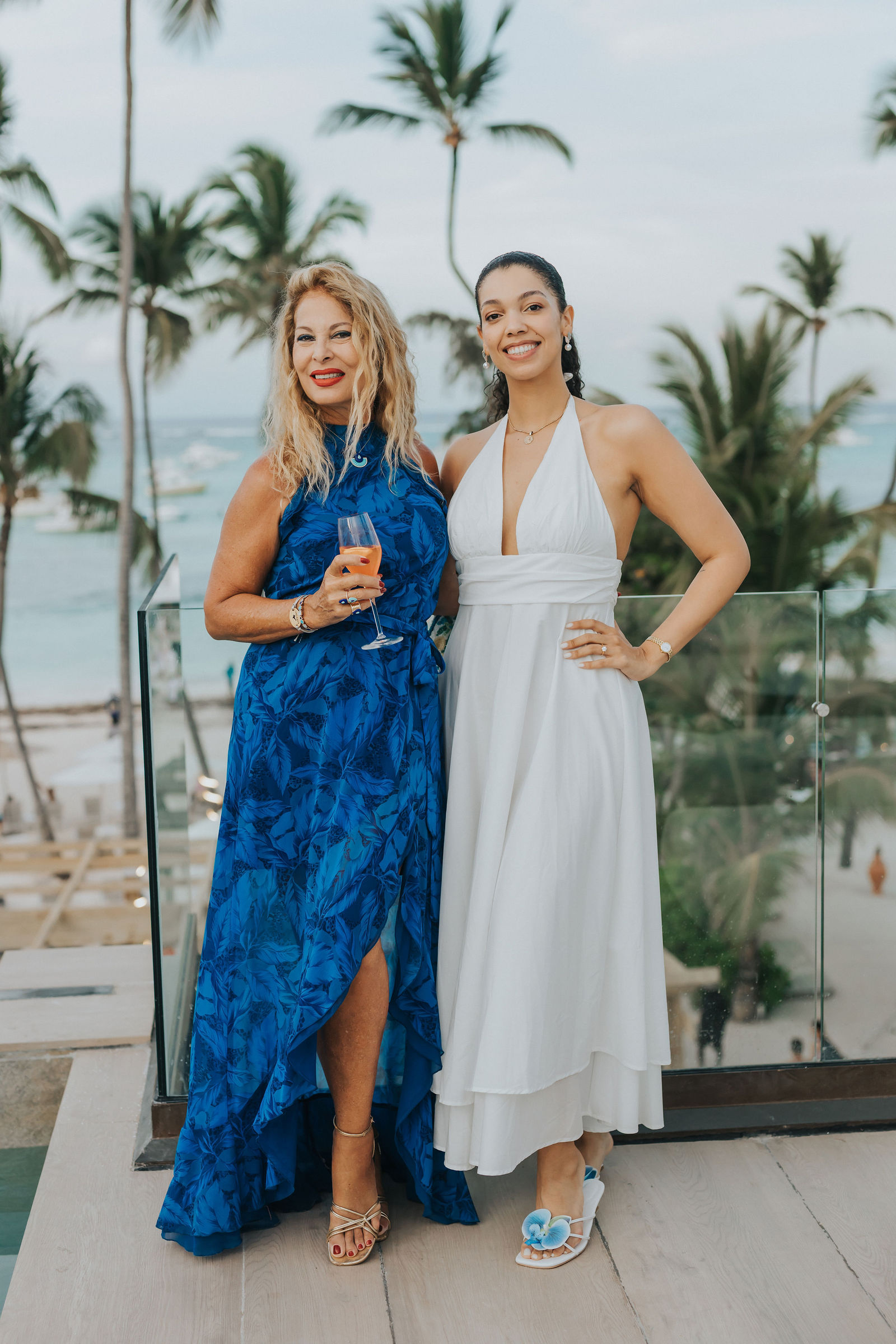 Guests posing together beneath the palms in blue attire