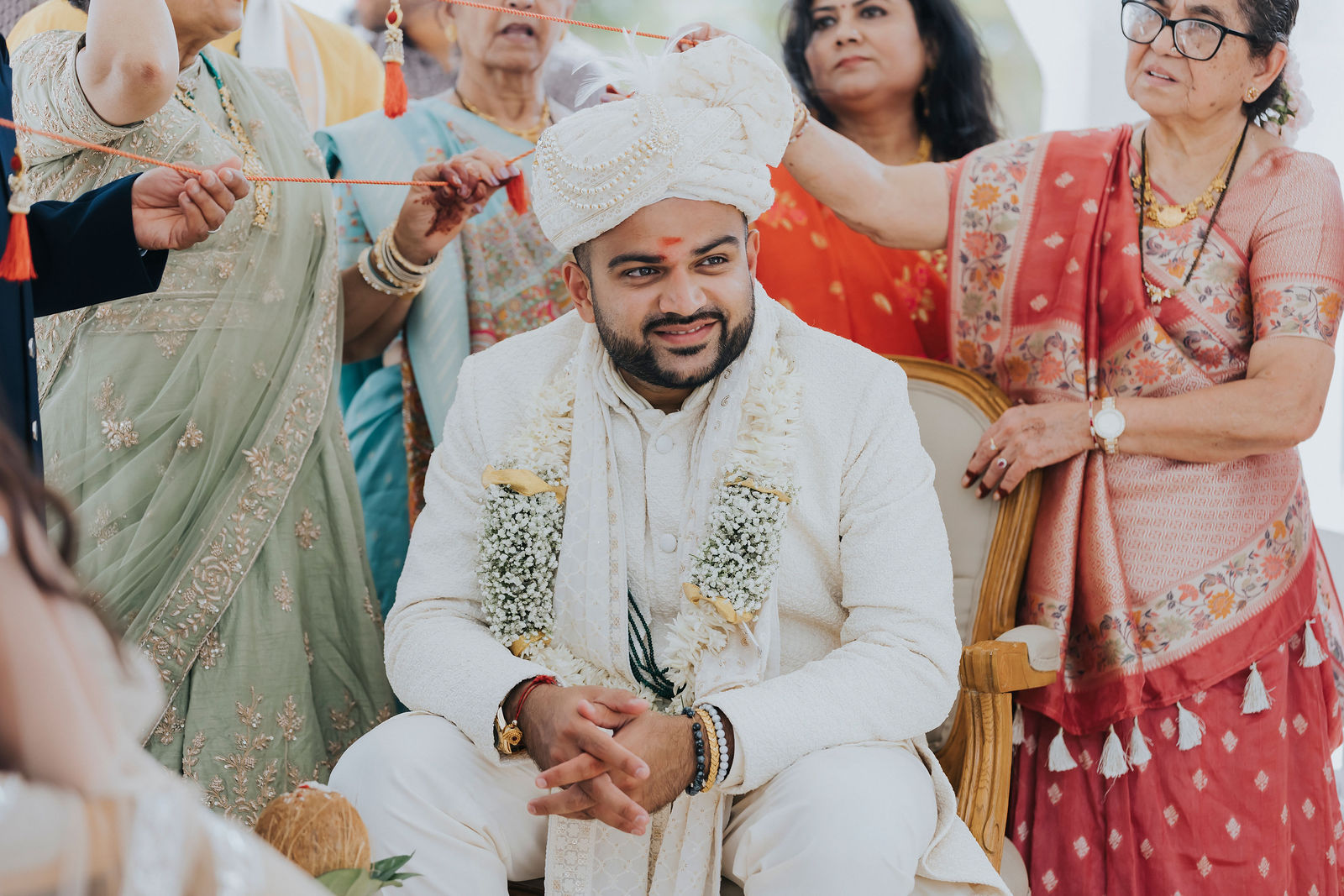 Family members performing a traditional ritual with the groom during the ceremony