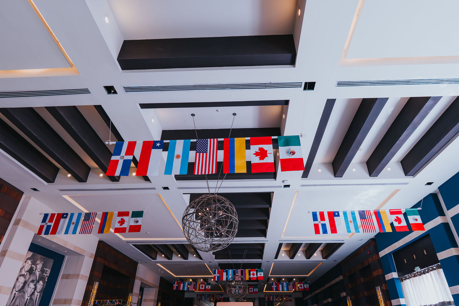 Welcome banner in three languages beneath a canopy of international flags
