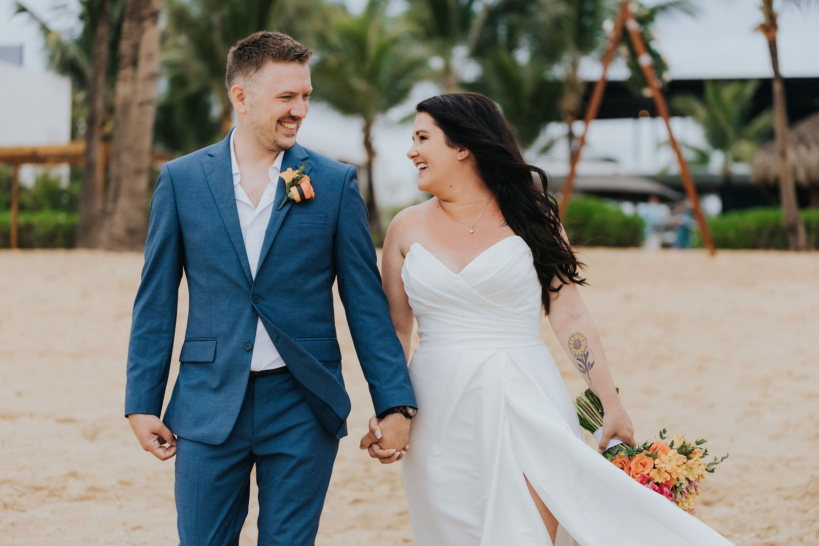 Couple walking hand in hand along the beach after the ceremony