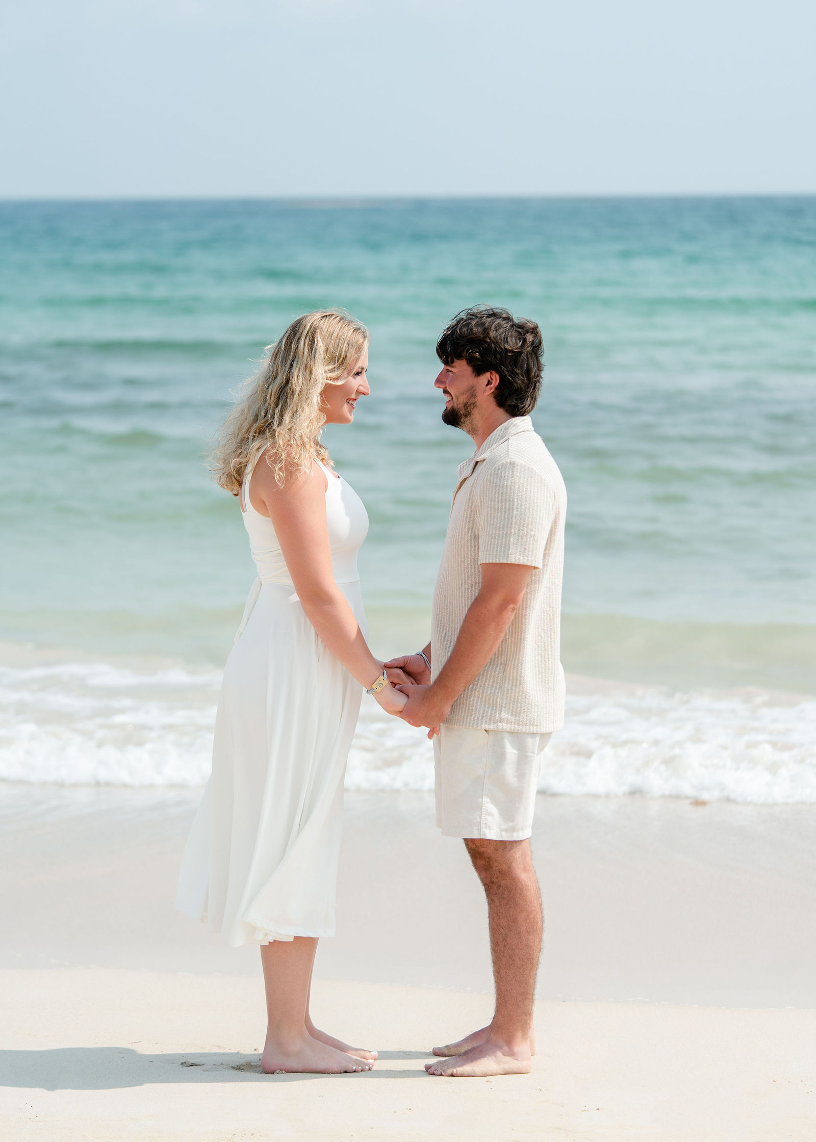 Greg and Jessica standing together facing the turquoise Caribbean sea