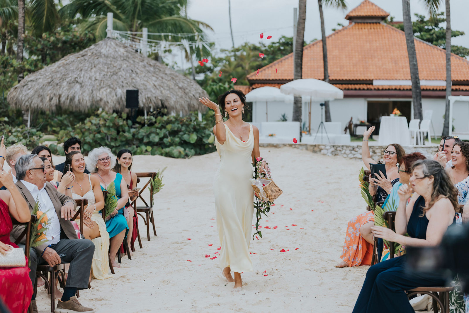 Bride walking down the sandy aisle over scattered petals