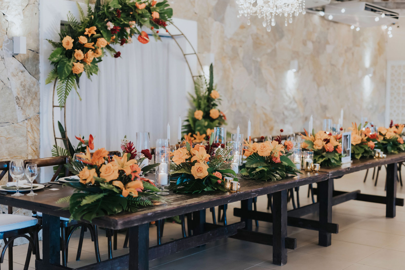 Long reception table beneath hanging florals and candlelight