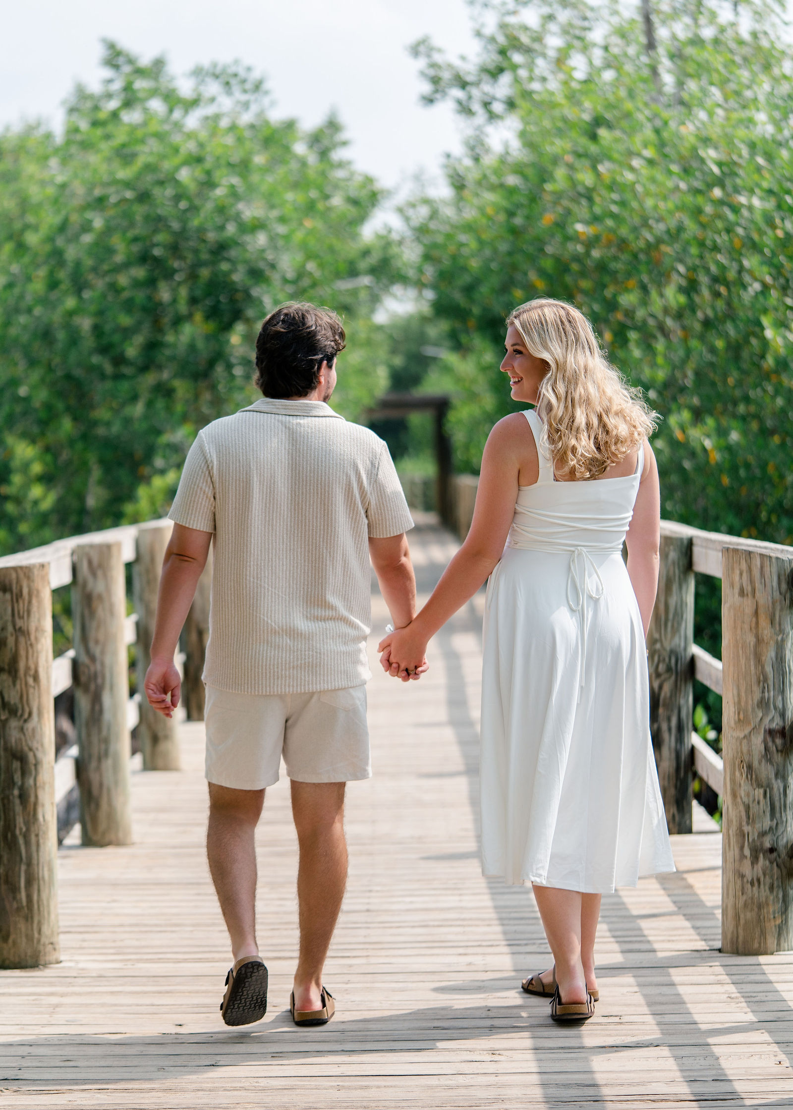 Greg and Jessica walking away together along the wooden boardwalk