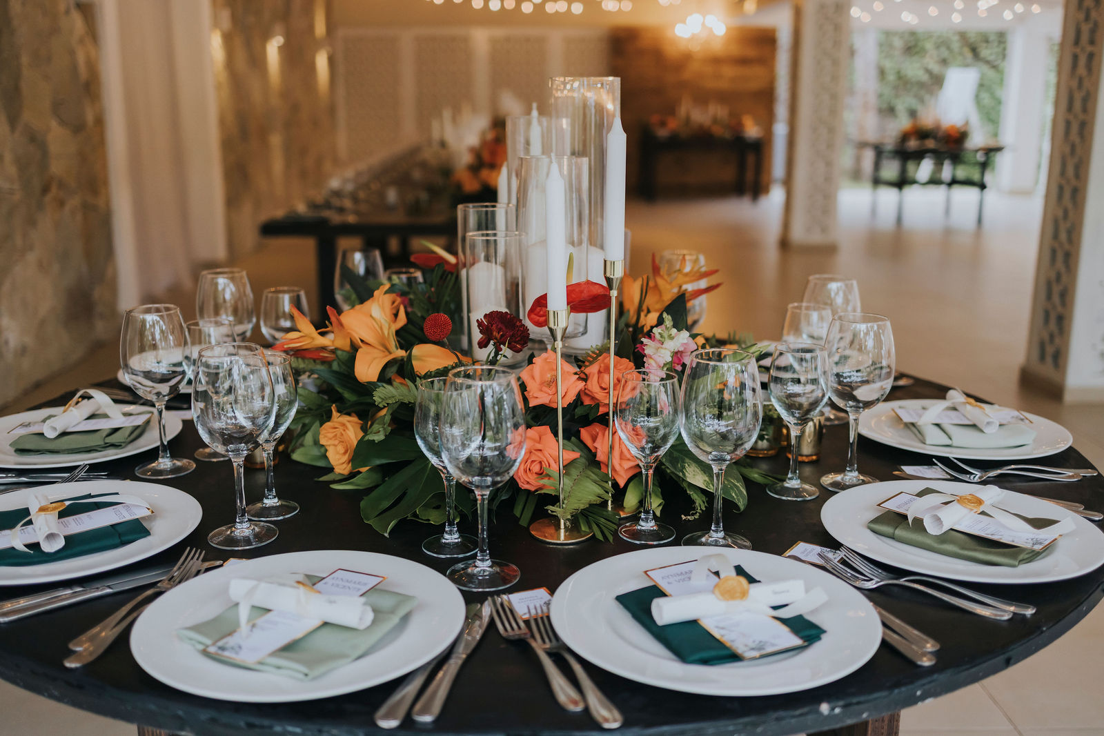 Reception tablescape with orange florals, candles and gold accents