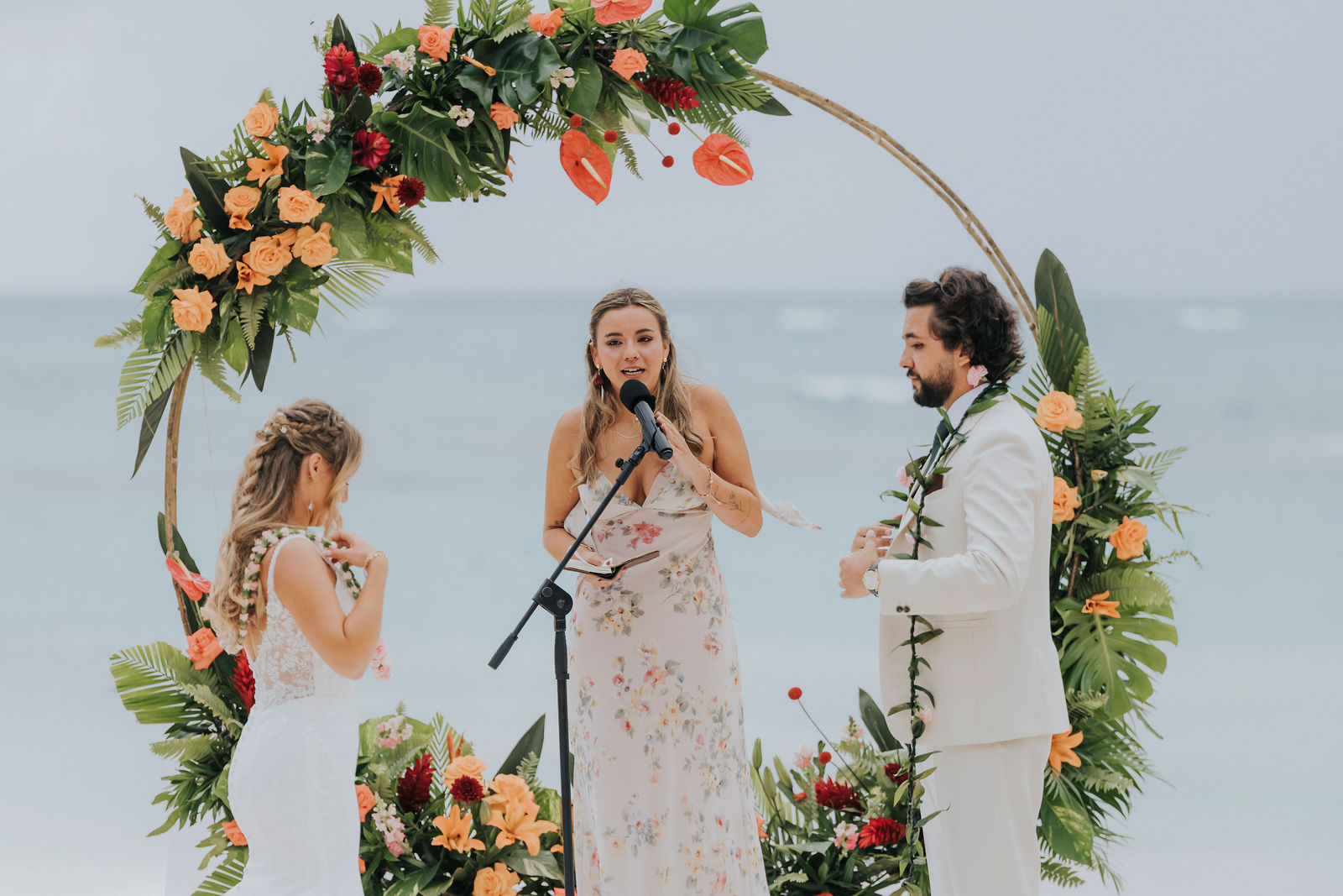 Couple exchanging vows in front of the floral ceremony arch