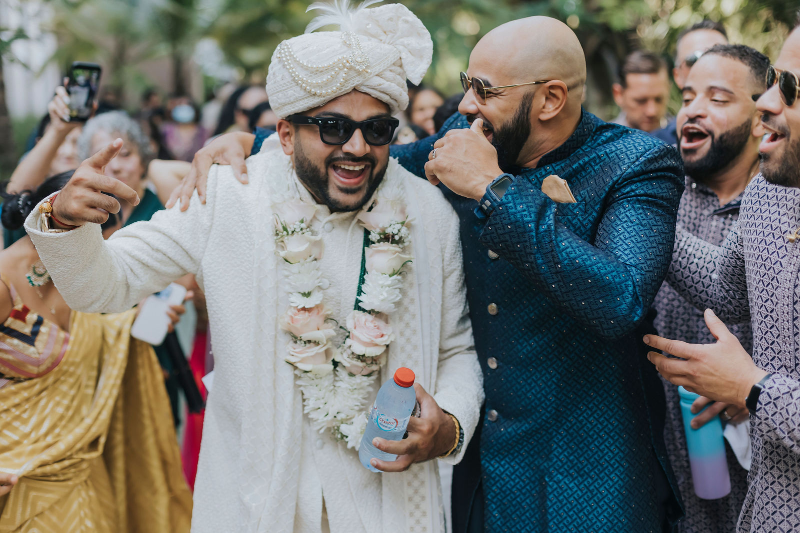 Guests celebrating around the groom during the baraat procession